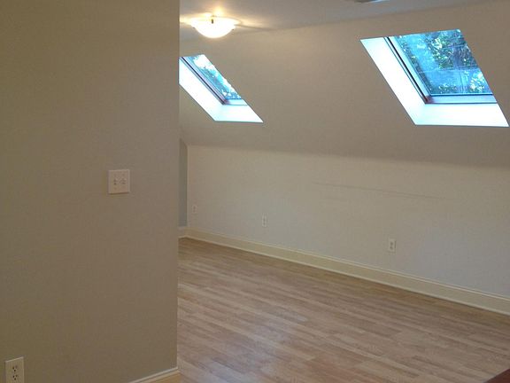 Living room. viewed from study area, showing skylights and wood floor.
