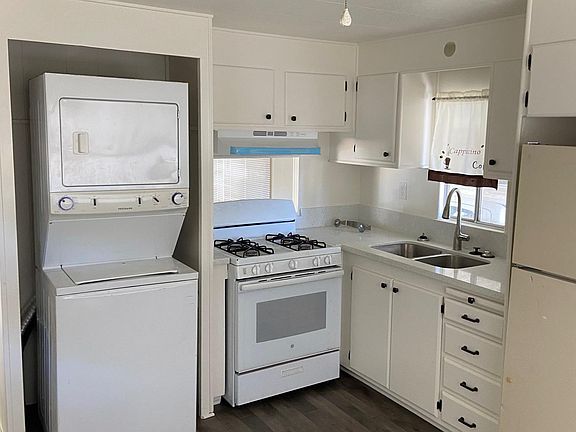kitchen with washer/dryer combo and fridge