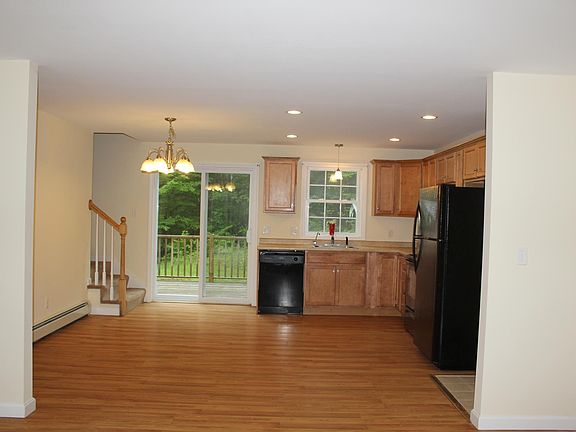Kitchen, dining area, stairway to second floor, slider to deck (photographed from the living room).