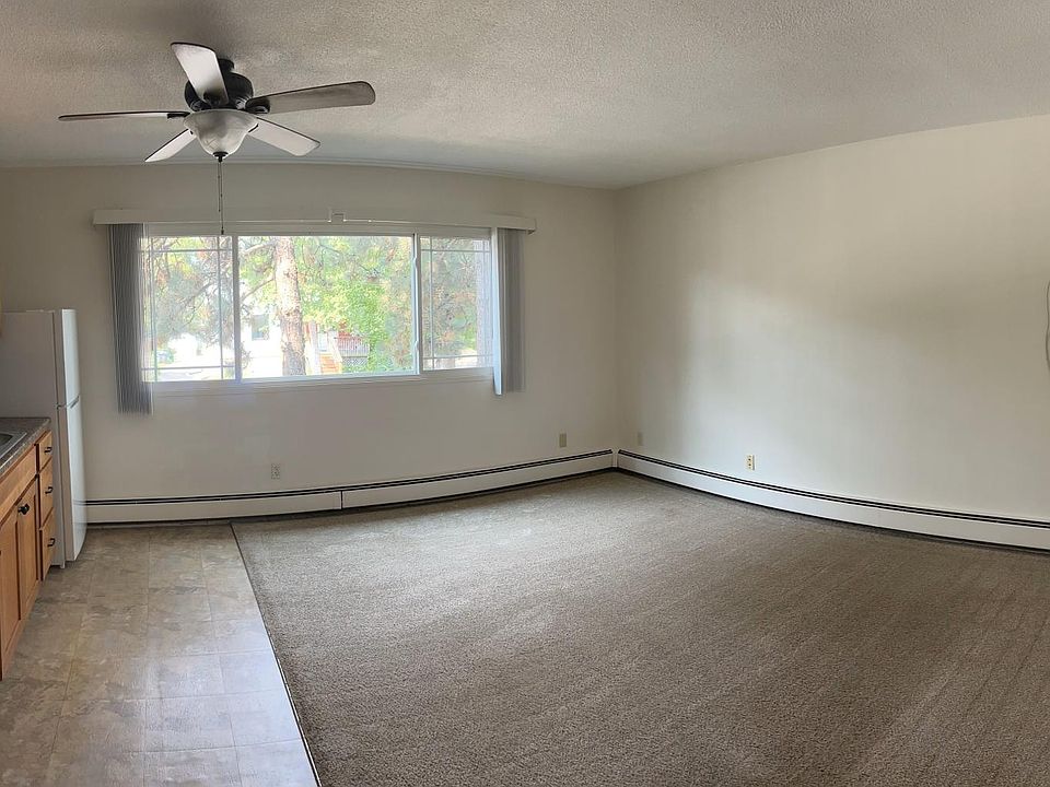 The living room is spacious, with an oversized window, ceiling fan, and air conditioning.
