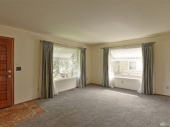 This living room welcomes you with large light and bright windows making this space a cheerful space.