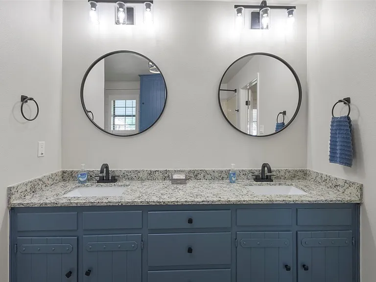 Double vanity with a granite-look countertop, integrated sinks, and matte black fixtures