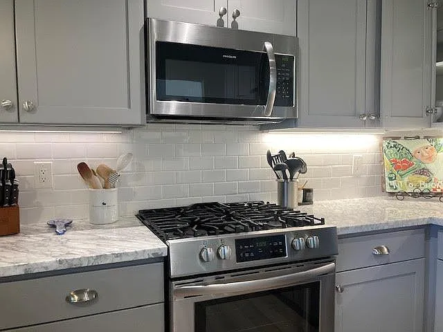 gas stove, marble counters, subway tile