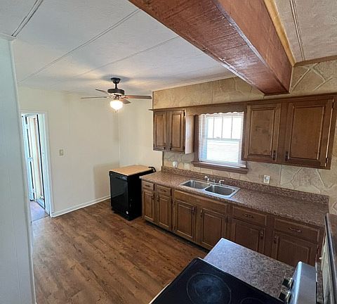 Another view of kitchen, from brick partial wall. Glass top electric stove is in foreground.
