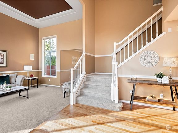 Vaulted ceilings, wainscotting, tray ceiling, newly refinished hardwood floors and new carpeting throughout greet you in the large foyer!>
