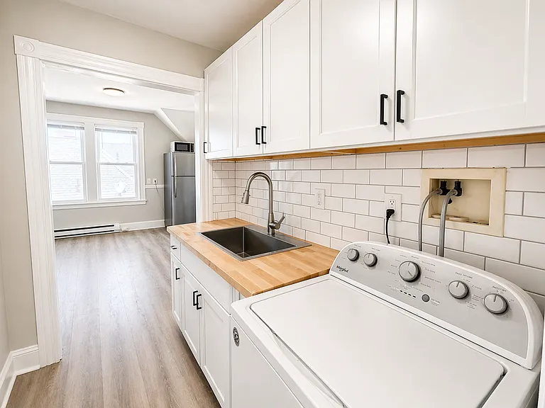 Refreshed kitchen with new fixtures, cabinets, subway tile backsplash. In unit washer.