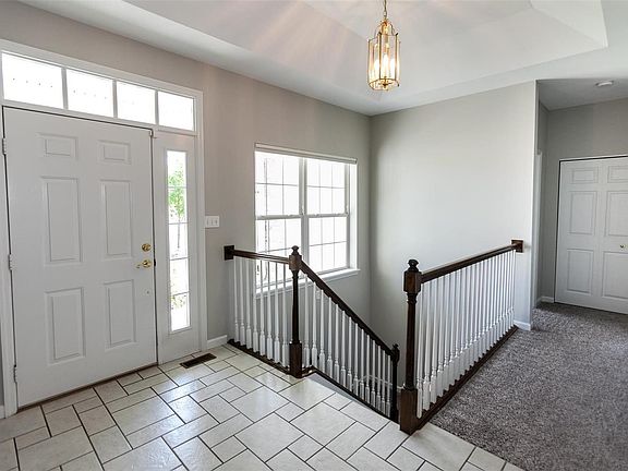 Ceramic Tile Entryway with stairs leading to lower level.