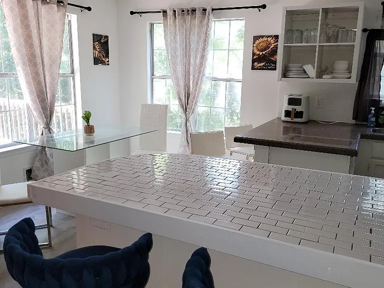 upgraded kitchen with open plan and table as well as 4 bar stools for additional seating