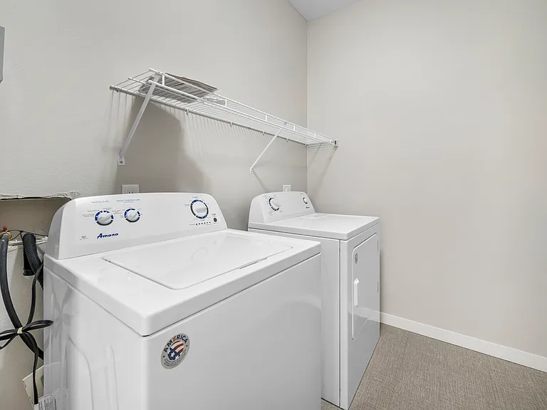 Modern laundry room with efficient washer and dryer, featuring sleek shelving and ample space for convenience. Modern laundry room with efficient washer and dryer, featuring sleek shelving and ample space for convenience.