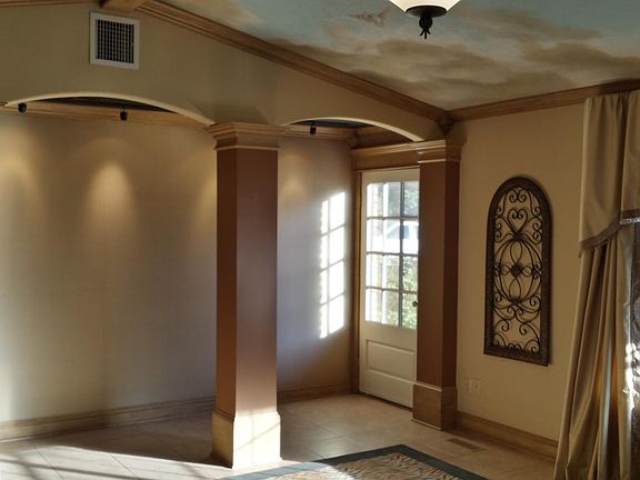 Tiled floors with large area rug and arched entry