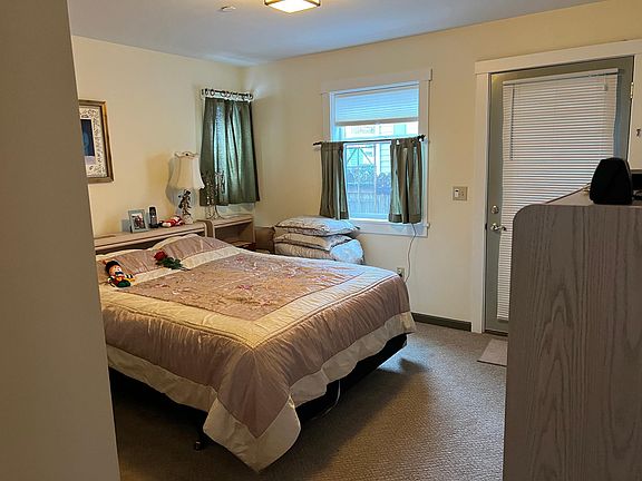 Main floor bedroom with walk in closet and door to back deck