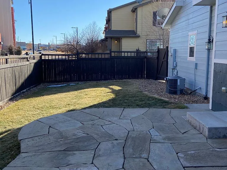 View of large side yard and stone patio
