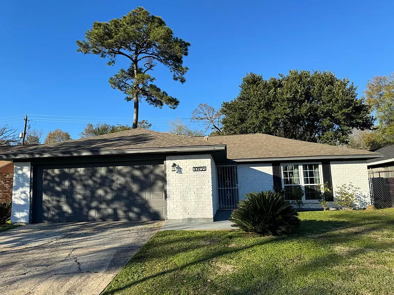 Front elevation includes newly installed energy efficient windows, black shutters, 2 car garage, with low maintenance landscaping.