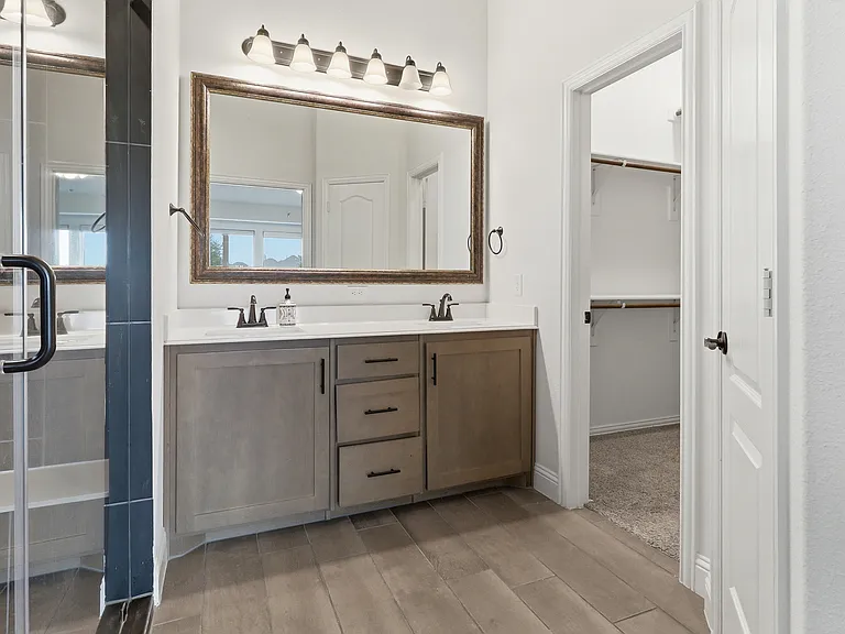 Dual vanity with light wood-finish cabinetry and white countertops