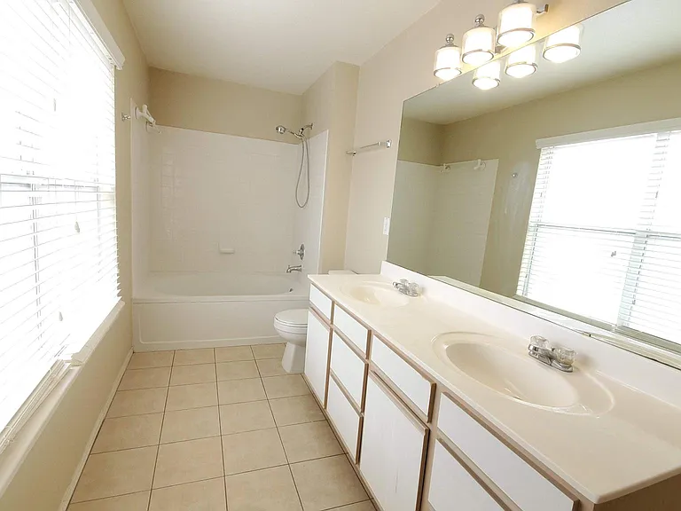 Main bathroom with double vanity and many windows, super bright.