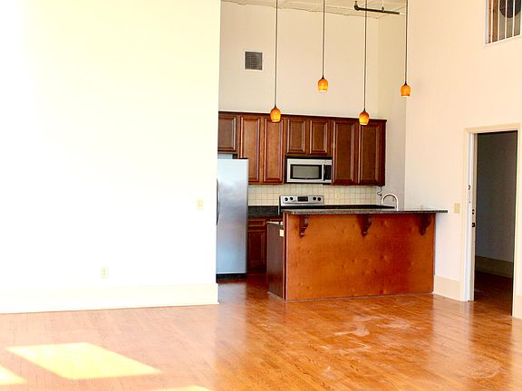 Stainless steel kitchen appliances. Open-concept to large living area.