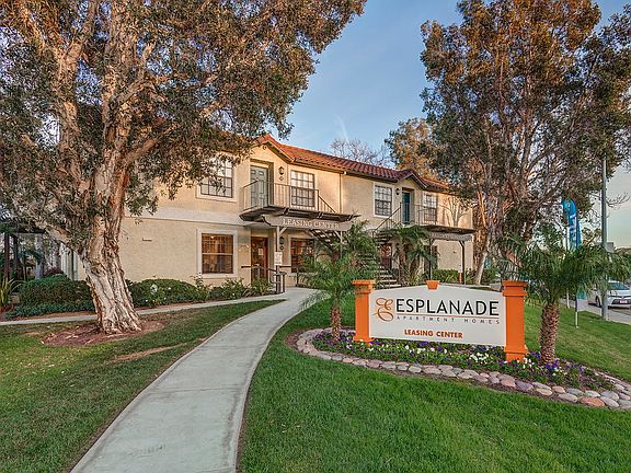 Exterior of leasing office surrounded by trees and grass area.