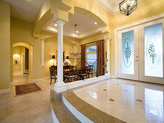 The "wow" factor begins with this grand iron railed marble foyer.