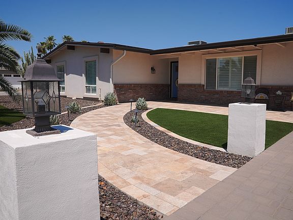 Front view of house - Updated desert landscaping with travertine and paver driveway.