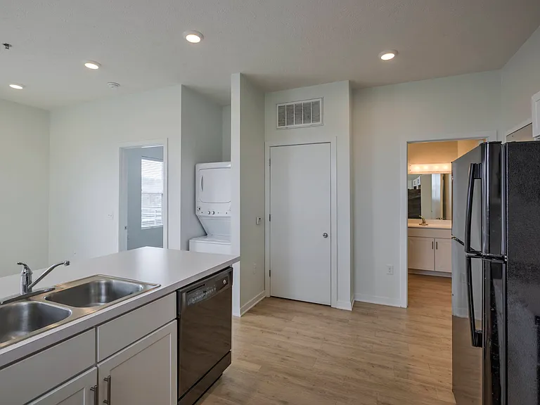 Kitchen, living room, bedroom entrance and bathroom entrance in a unit at The Rise.