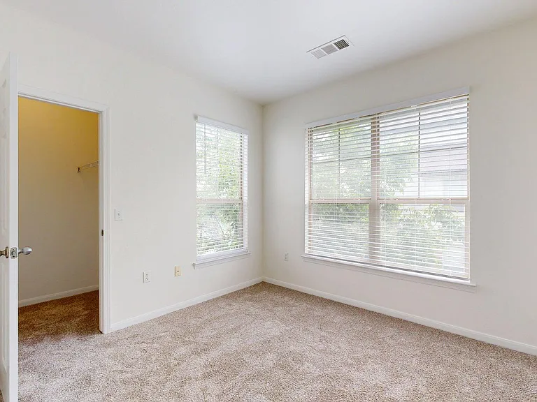 Spacious apartment bedroom with carpet floor.