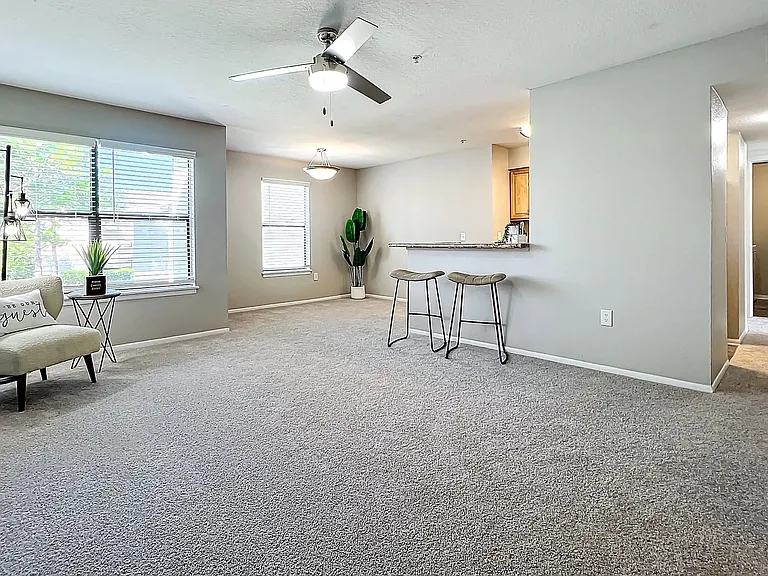 Discover the spacious and inviting living room featuring large windows, modern lighting, and an open layout perfect for relaxation and entertainment.