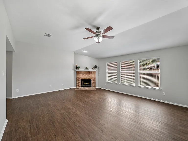 BIG LIVING Room with tall ceilings, windows, woodburning brick fireplace & fan