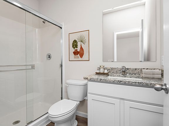 The master bathroom has a large vanity and a step in shower.