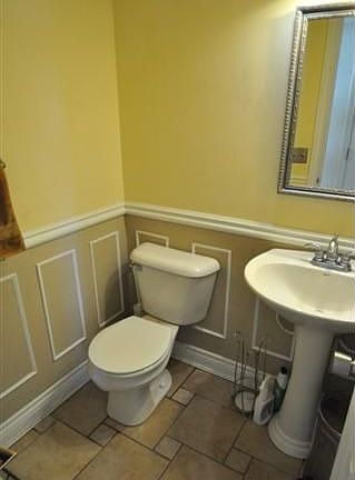 Half bath with custom flooring and woodwork. 