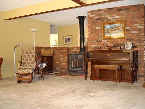 Living room has open beams and wood stove