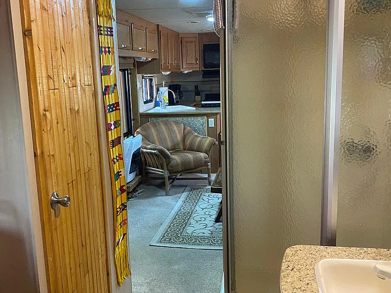 Bedroom has a separate sliding door that closes off from the living room. Toilet is located in a separate room in the bedroom. Shower and sink are located in the bedroom as well.