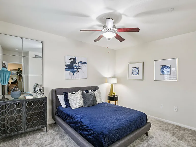A sleek bedroom in a Providence Uptown Houston apartment, with large windows and contemporary finishes.
