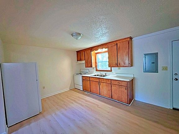 Large eat-in kitchen with new flooring, new refrigerator, stove, and a laundry closet with washer/dryer hook ups.