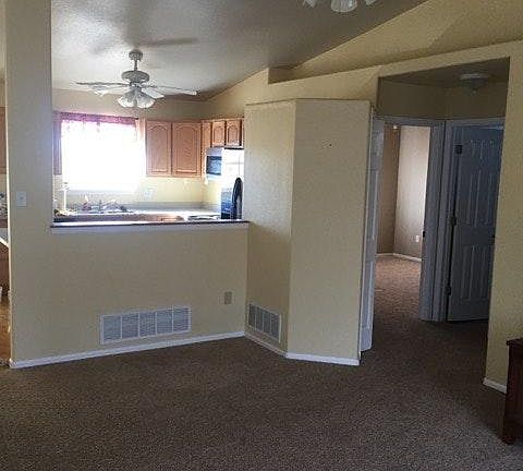 Front room looking into kitchen. Kitchen has hard wood floor
