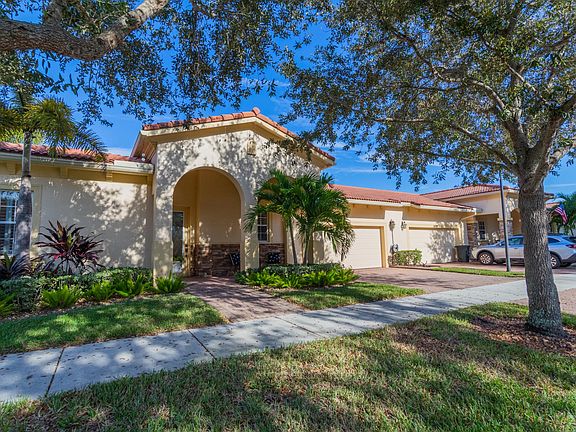 Architectural accents and traditional brick pavers on entry walkway, driveway, and covered patio