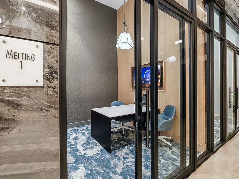 Elegant meeting room with modern decor, featuring plush seating, a contemporary table, and vibrant artwork. Ideal for creative discussions and professional gatherings.