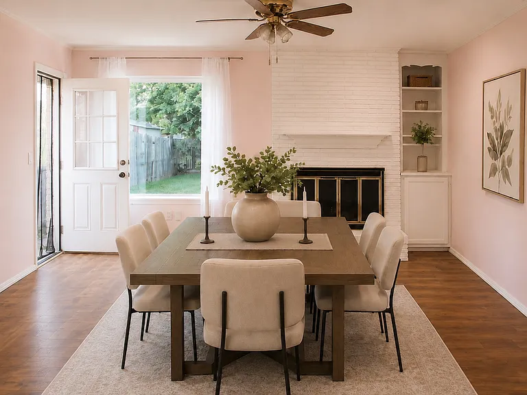 Large room off the kitchen with brick fireplace configured as a dining room. View of the cabinet and large window facing the backyard.