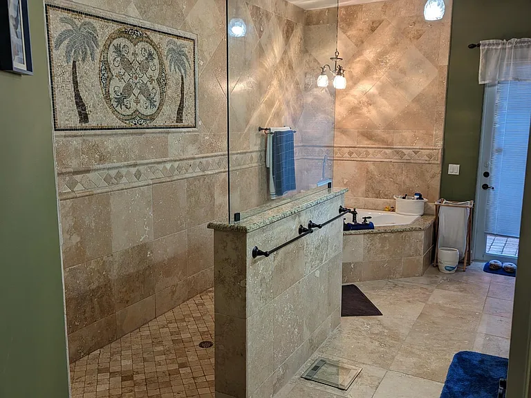 Master Bath. The master bathroom is impressive and ornate with travertine all around, a roman shower (rainfall shower head and adjustable hand-held head with magnetic mount), built-in dispensers, a jacuzzi tub for two, his and hers sinks and granite count