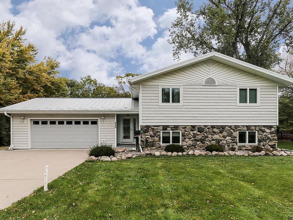Front of home. Garage door has window, roof is steel, stone accent on front. Newer windows in home.