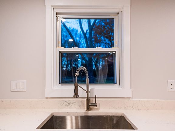 Stainless steel sink with disposal and view of woods