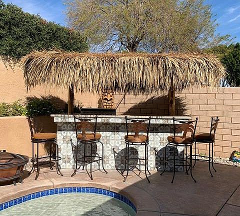 Palapas by pool with refrigerator and BBQ.