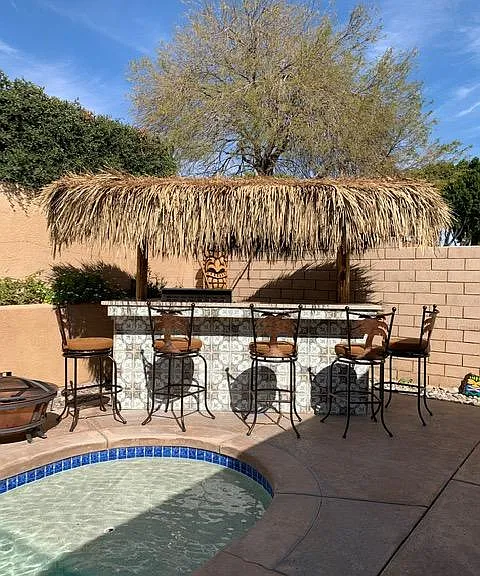 Palapas by pool with refrigerator and BBQ.