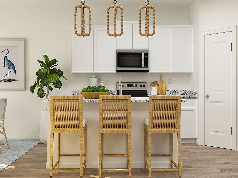 The kitchen of the Granite has white cabinetry and sprawling granite countertops.