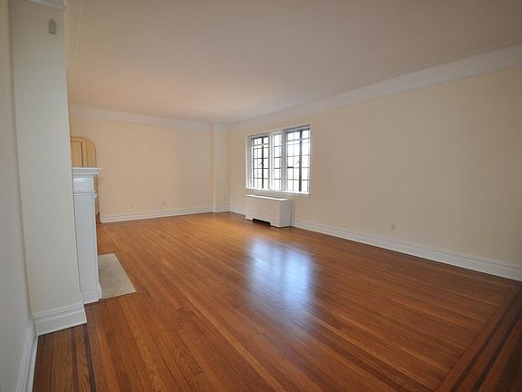 Large Living Room overlooks Garth Woods, has a working fireplace and refinished hardwood floors. Cove ceiling and arched doorways complete the look.