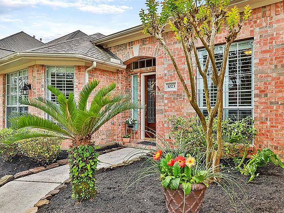 Winding sidewalk with moss rock leads you to the front door.