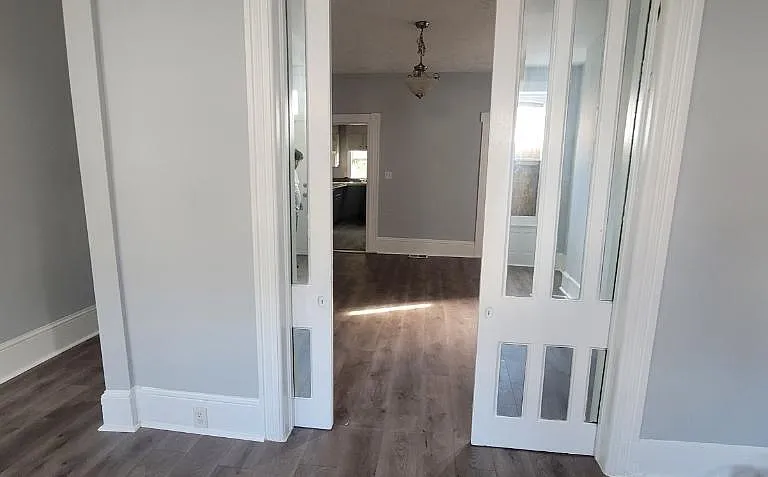 Pocket doors separate living and dining rooms. Also, the corridor that leads to the 2nd floor is on the left