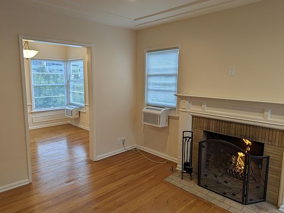 Adjoining, intimate dining room with hardwood floors and GE Profile saddle air conditioning unit.