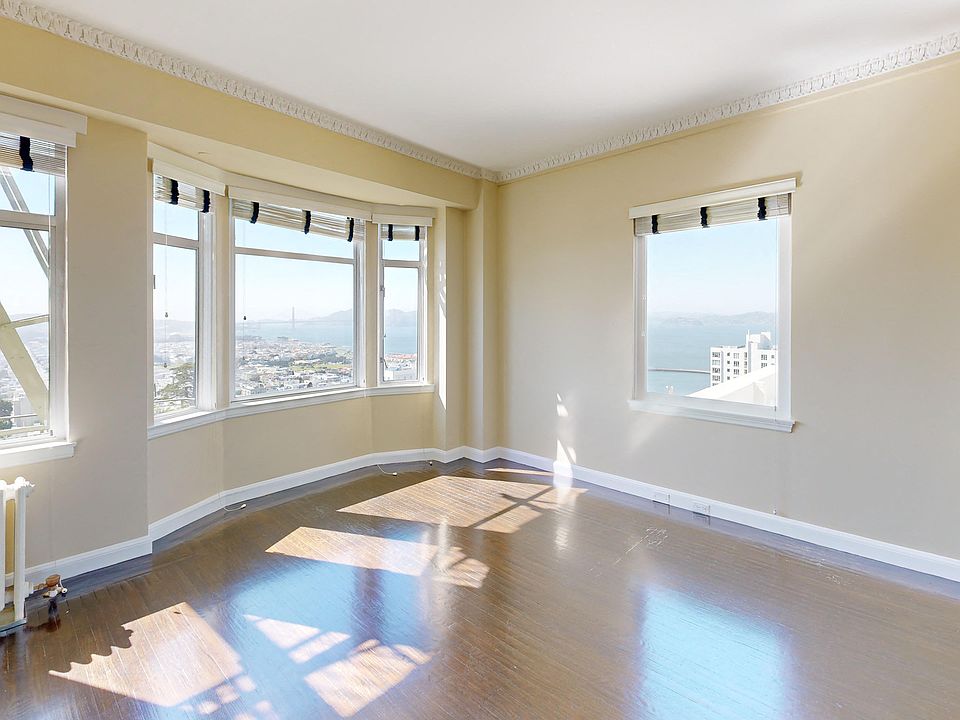 Spacious bedroom with wood-like flooring and a large window offering natural light