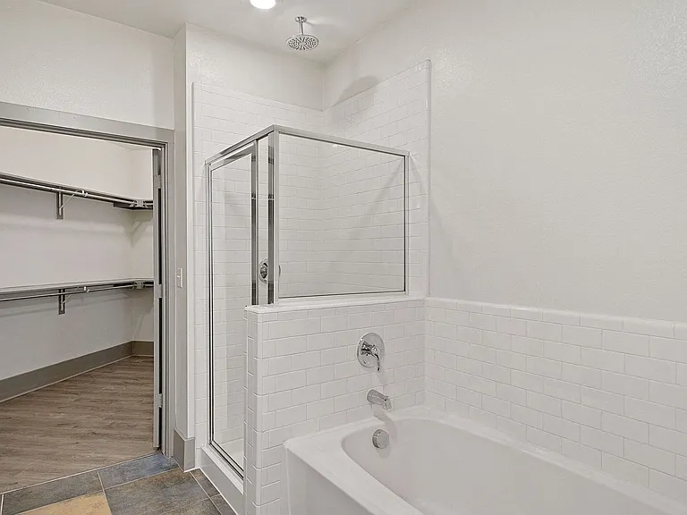 Bathroom with closet, stand-in shower, and soaking tub