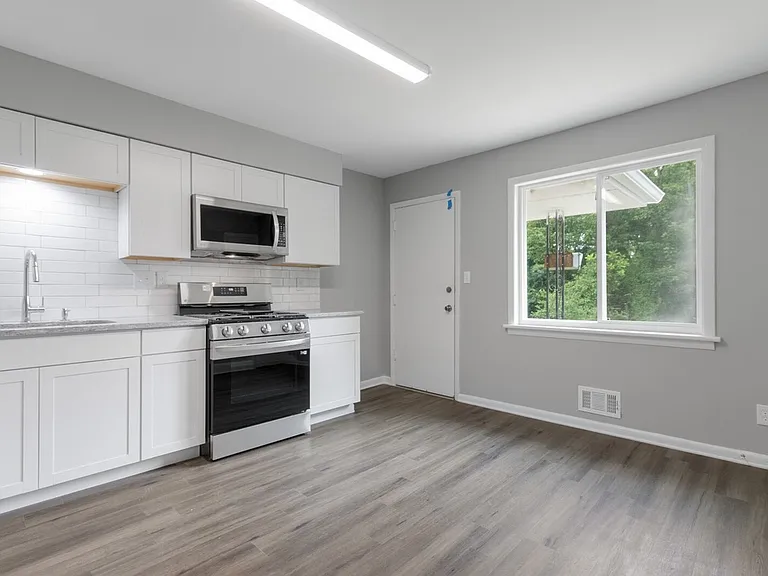 Kitchen includes large window into backyard & parking area